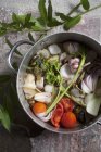 Pot-roasted vegetables in saucepan over wooden surface — Stock Photo