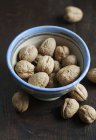 Walnuts with shell in bowl — Stock Photo