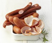 Sausages and sliced ham — Stock Photo