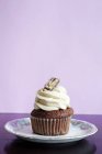 Cupcake de chocolate cubierto con crema - foto de stock