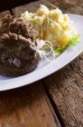 Haggis with mashed potato  on white plate over wooden surface — Stock Photo