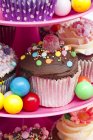 Cupcake e caramelle colorate sullo stand della torta — Foto stock