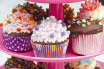 Coloridos cupcakes en soporte de pastel - foto de stock