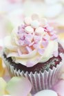 Cupcake decorated with pink sugar hearts — Stock Photo