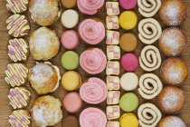 Reihen von Cupcakes, Scones und Macarons — Stockfoto