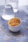 Closeup view of dried marigold petals in white bowls — Stock Photo
