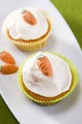 Cupcakes with icing and little sweet carrots — Stock Photo