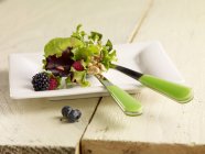 Green salad with berries — Stock Photo