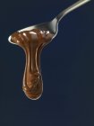 Melted Chocolate flowing from spoon — Stock Photo