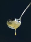 Closeup view of vanilla sauce dripping from ladle — Stock Photo