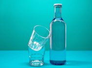 Vista de perto de copos de água com uma garrafa de água — Fotografia de Stock