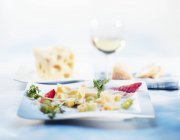 Pedaços de queijo com uvas — Fotografia de Stock