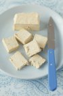 Closeup view of sliced vanilla halva with knife on plate — Stock Photo