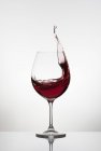 Красное вино, брызгающееся из стекла — стоковое фото