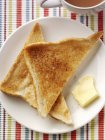 Nahaufnahme von oben auf Toasts mit Butter und Tee — Stockfoto