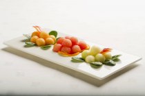 Différentes boules de melon sur plaque blanche — Photo de stock