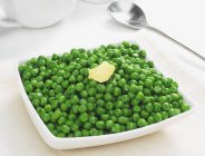 Peas with knob of butter — Stock Photo