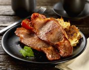 Smoked fried bacon with potato rosti — Stock Photo