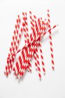 Top view of red and white drinking straws on a white surface — Stock Photo