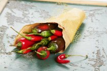 Paper bag of fresh chilli peppers — Stock Photo
