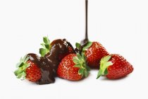 Chocolate pouring on fresh strawberries — Stock Photo
