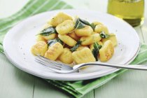 Home-made Gnocchi with sage and fork on plate — Stock Photo
