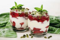 Vista de primer plano del yogur griego con fresas y pistachos - foto de stock