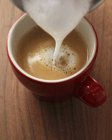 Verter espuma de leche en espresso - foto de stock