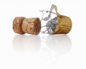Closeup view of Champagne cork with metal foil and wire holder on white background — Stock Photo