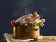 Hühnchen mit Gemüse in einem Kupfertopf über der Holzoberfläche schmoren — Stockfoto