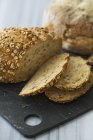 Pão de semente parcialmente fatiado com aveia — Fotografia de Stock
