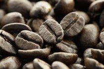 Vista de primer plano de granos de café secos montón - foto de stock