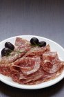 Шматочки салямі з оливками — стокове фото