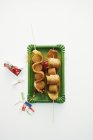 Top view of La ola curried sausages on skewers on green paper plate and white background — Stock Photo