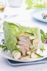 Chicken salad with quail's eggs and cucumber in a leaf lettuce — Stock Photo