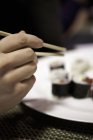 Hand greift nach einem Stück Sushi — Stockfoto