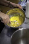 Hands whisking egg yolk and sugar — Stock Photo