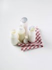 Повышенный вид различных йогуртовых напитков на клетчатой салфетке — стоковое фото