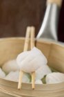 Dim sum on chopsticks in steamer — Stock Photo