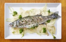 Pesce basso al forno con prezzemolo e limone — Foto stock