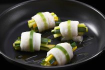 Pesce zander avvolto intorno a bastoncini di zucchina in padella — Foto stock