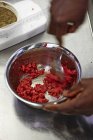 Mani che mescolano carne macinata con spezie — Foto stock