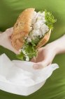 Вид крупним планом жінка тримає курячий бутерброд — стокове фото