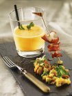 Cold carrot soup with a fried lobster skewer and mango salsa — Stock Photo