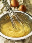 Closeup view of beaten mayonnaise with a whisk in a mixing bowl — Stock Photo