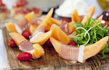 Prosciutto ham with melon and rocket — Stock Photo