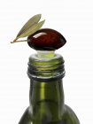 Oliva encima de la botella de aceite de oliva - foto de stock