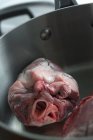 Raw lamb heart in saucepan — Stock Photo