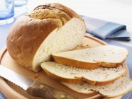Pão branco parcialmente fatiado — Fotografia de Stock