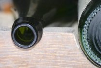 Vista close-up de garrafas de vidro em uma prateleira de madeira — Fotografia de Stock